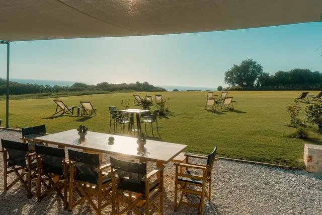 Long dining table at Leventes with an uninterrupted view over the lawn to the Ionian Sea