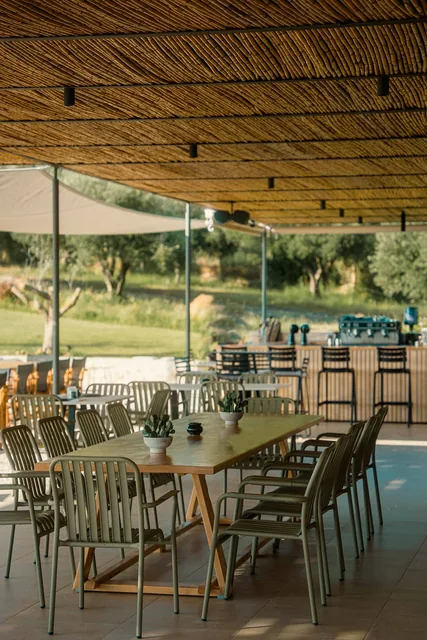 Long dining table beneath the reed roof at Leventes
