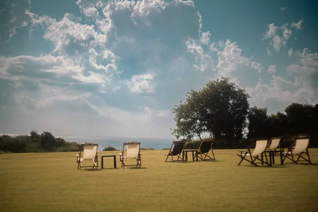 Deck chairs on the garden lawn under a wide summer sky