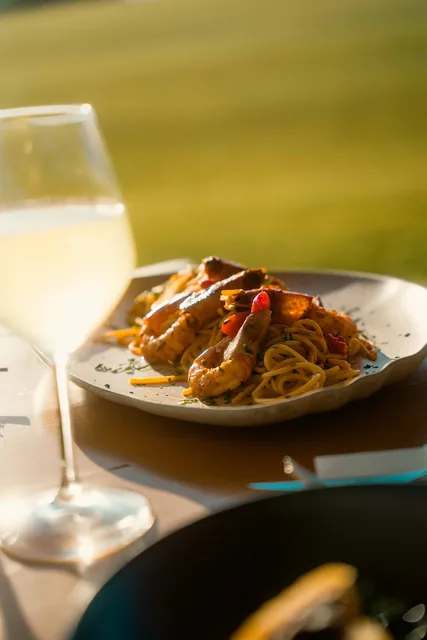 Shrimp pasta served with a glass of white wine