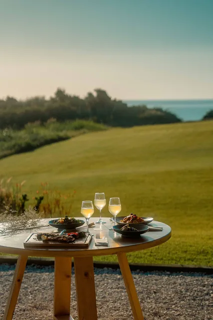 Round dining table with the Ionian Sea behind at sunset