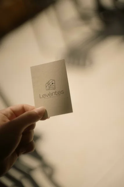 A hand holding the Leventes branded card