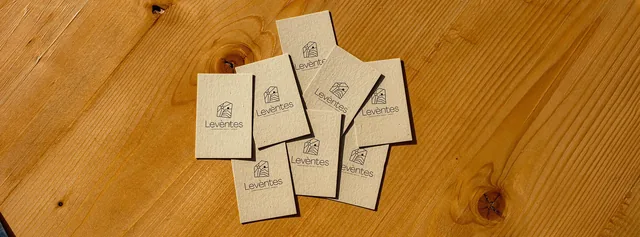 Leventes branded cards scattered on a wooden table
